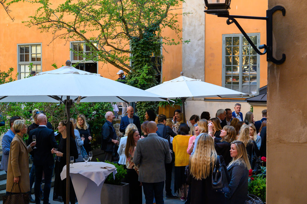 Personer minglar i trädgården